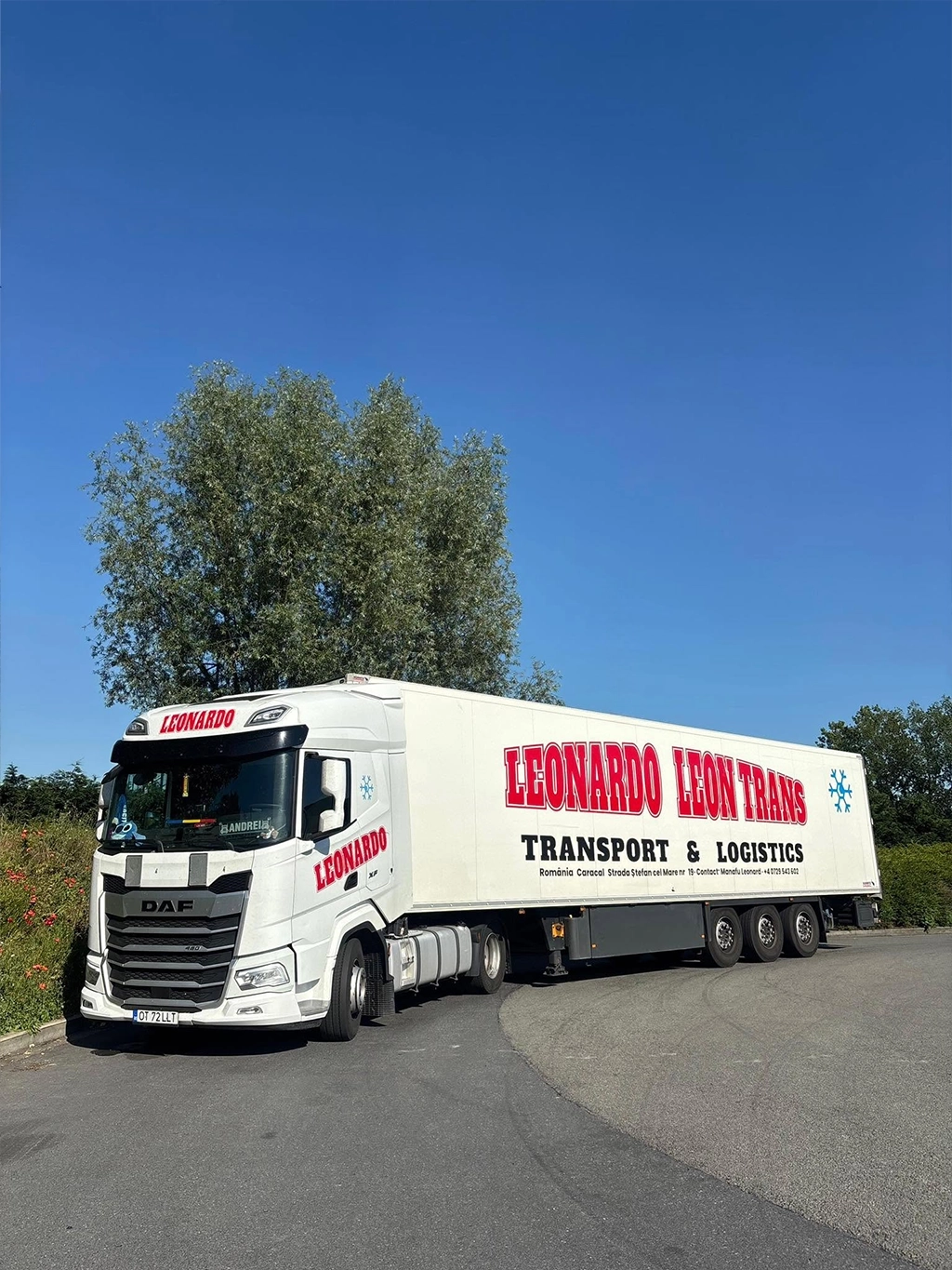 Ansamblu cap tractor DAF modern si semiremorca frigo inscriptionate cu datele companiei